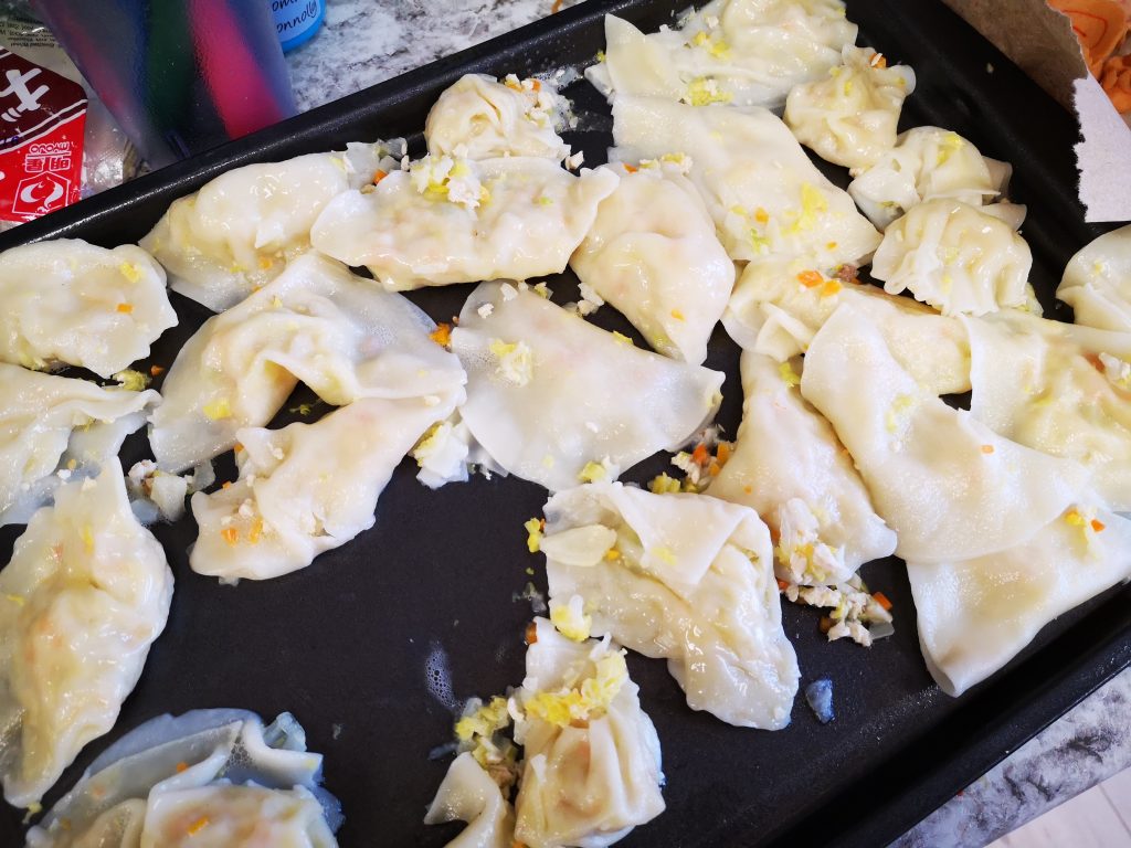 In a tray, cooked dumplings are cooling before being served to the children.