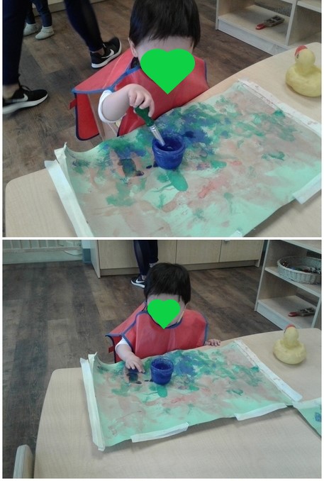 a child paints with watercolours on posters.